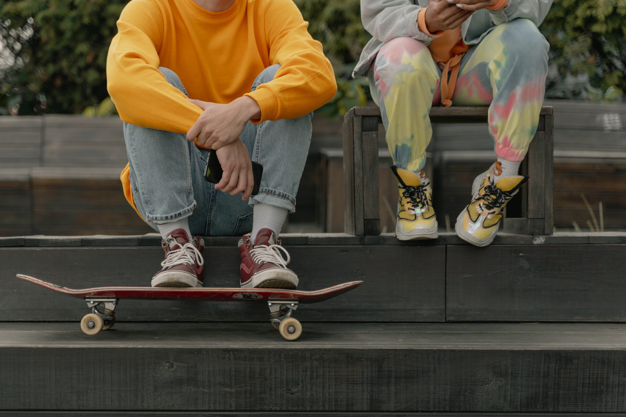 Młodzi chłopcy siedzący na schodkach z zafarbowanymi metodą tie dye spodniami dresowymi